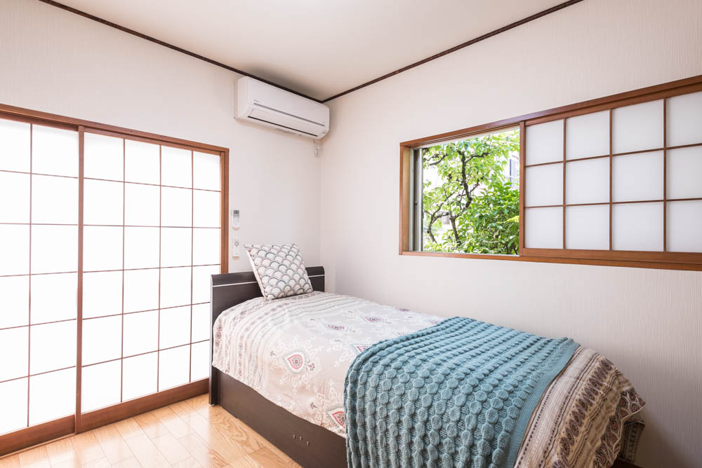 お父様の部屋となった１階の和室もフローリングにして、収納型のベッドを導入。桜を使った天井回りや障子はそのまま使い、愛着のある家の雰囲気を残しています。